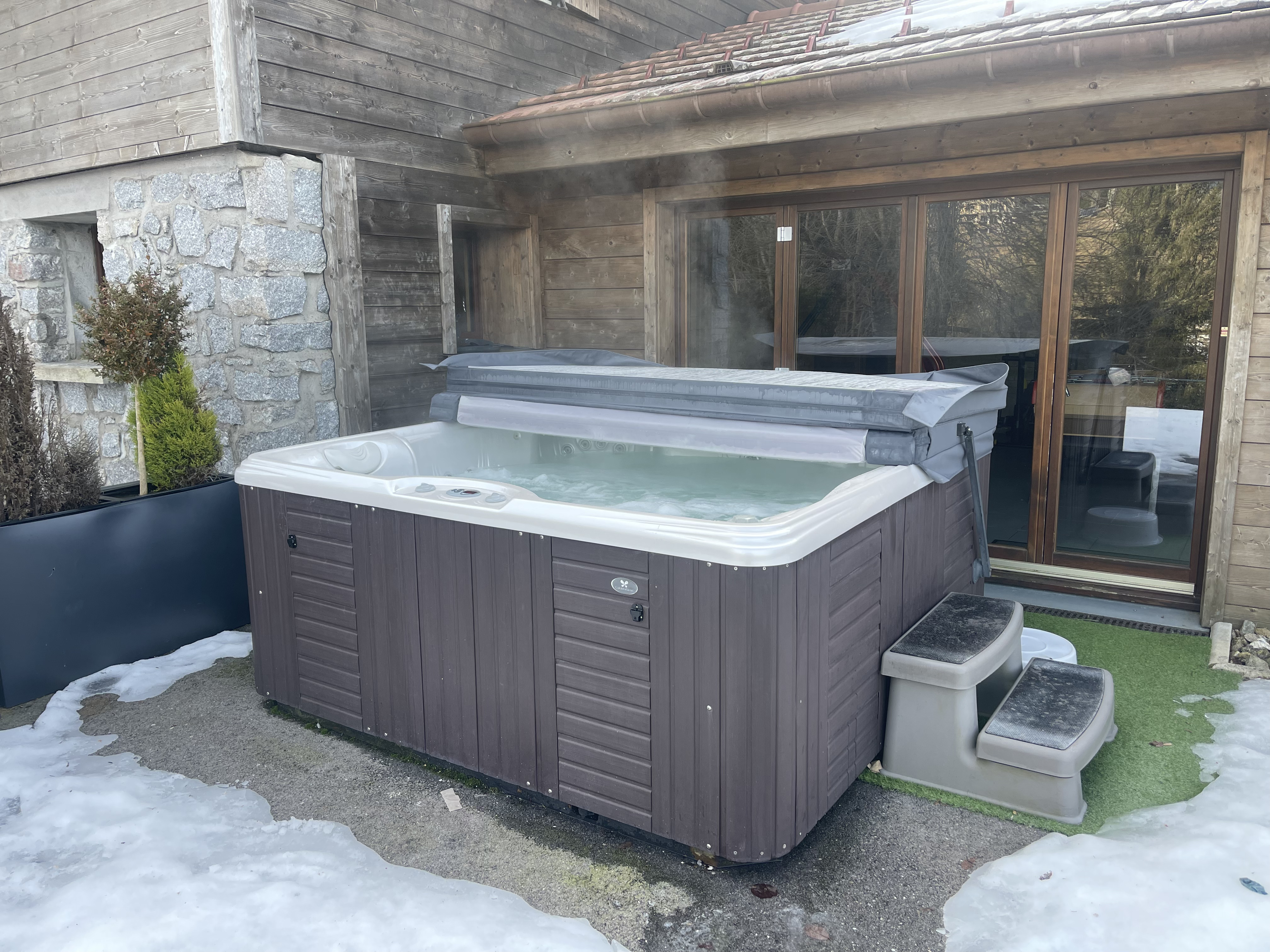 Jacuzzi extérieur hiver – façade pierre